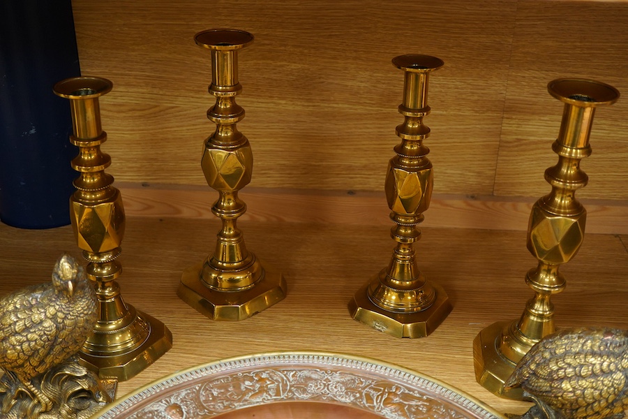 A group of copper and brassware to include candlesticks and an alms dish, 45cm in diameter